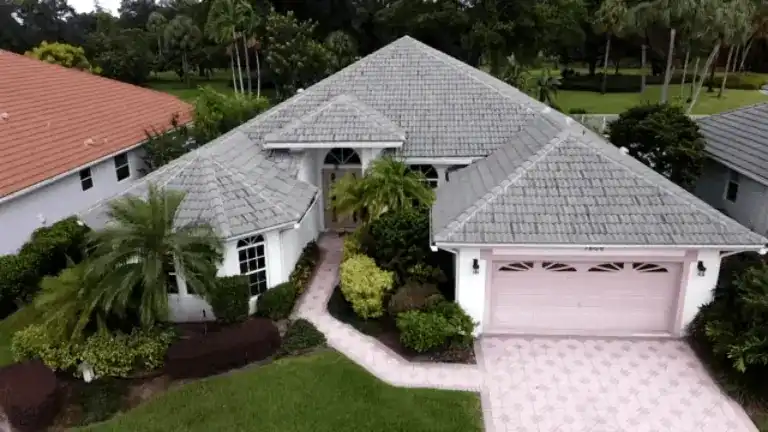 Dark gray tile roof on a single-story house with palms beside the driveway in Boca Raton