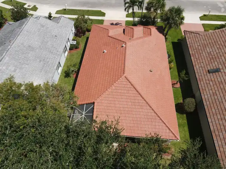 Vista aérea amplia de un techo de tejas color terracota en una casa entre árboles en un vecindario residencial en Boynton Beach