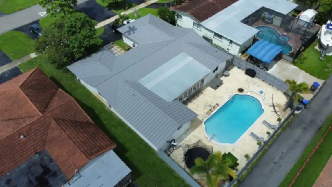 Gray metal roof home with pool aerial view