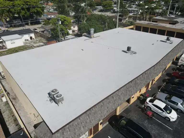 Flat roof on a commercial building beside a parking lot, photographed June 2025