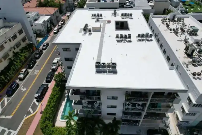 White flat roof with rooftop equipment on a multistory building beside a street