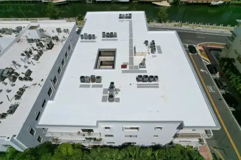 White flat roof with rooftop air conditioners on a waterfront building