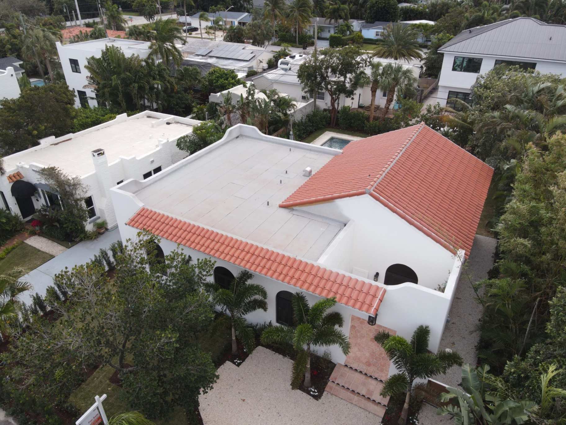 Clay tile roof with adjacent flat roof section in Palm Beach County