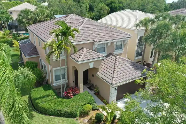 Gray tile roof on a two-story house with palms and a lawn in Royal Palm Beach, photographed May 2023