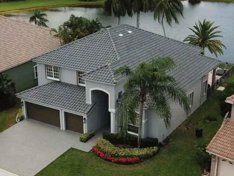 Techo de tejas grises de una casa de dos pisos junto al agua y palmeras en Royal Palm Beach, terminado en agosto de 2020
