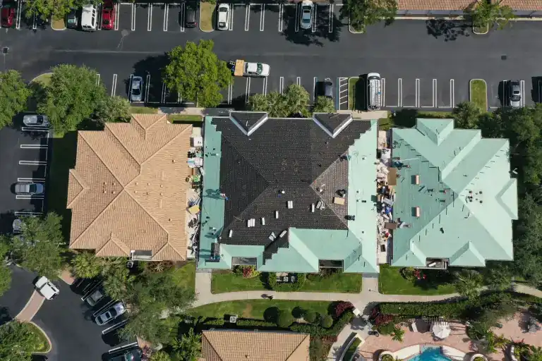 Overhead view of a flat roof section between tiled commercial buildings and parking in West Palm Beach, photographed May 2021