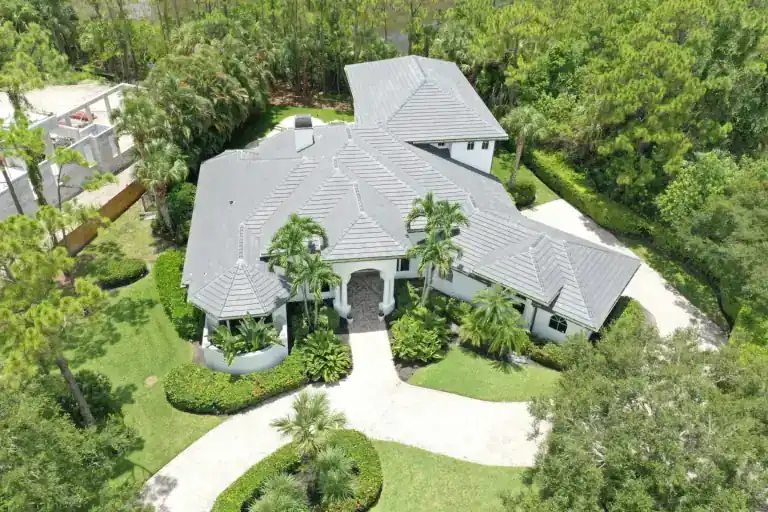 Gray tile roof on a detached house with a broad driveway and landscaped lawn in Oakmeade, West Palm Beach
