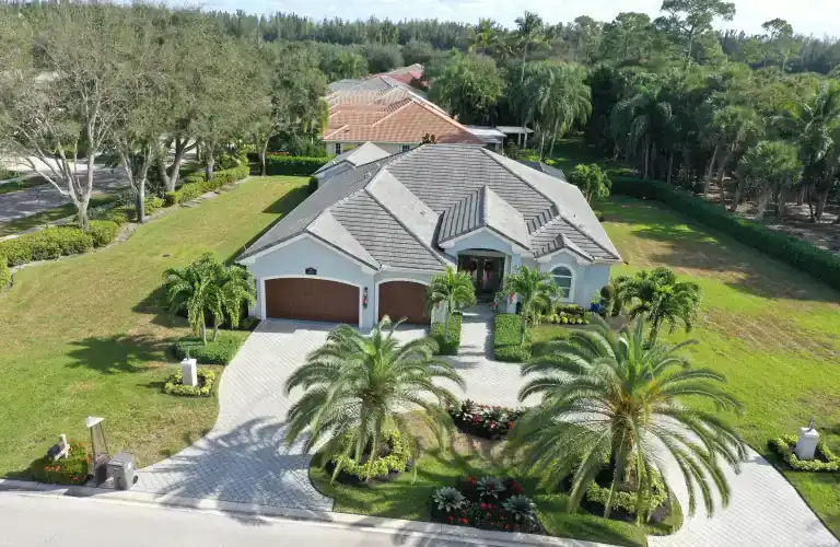 Gray tile roof on a detached house with a broad driveway and landscaped lawn in West Palm Beach
